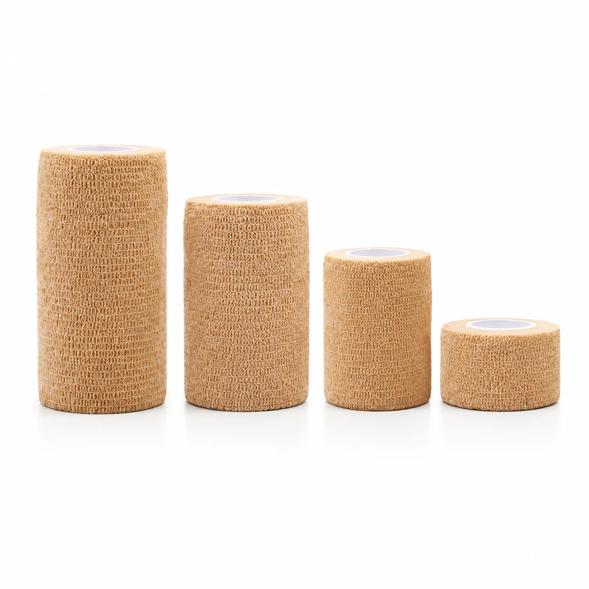 Four rolls of tan self-adhesive elastic bandage in graduated widths, on a white background